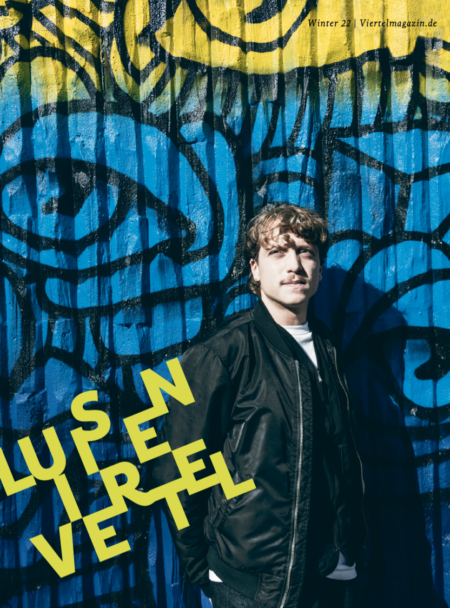 Titelbild Luisenviertelmagazin Leo Mazzarella vor Graffiti in blau und gelb