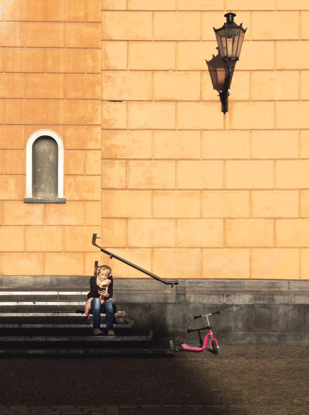 Sonnenpause: Eine Frau sitzt auf der Treppe der Laurentiuskirche im Wuppertaler Luisenviertel