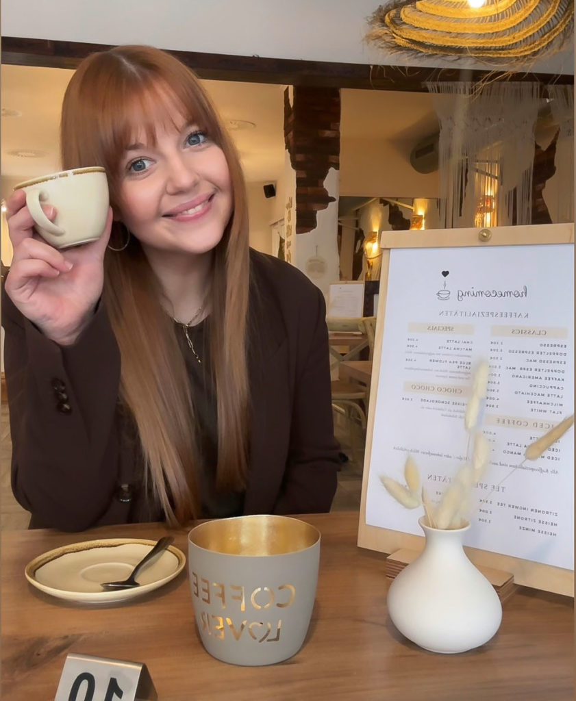 Lisa-Marie Hofmann im Cafe Homecoming mit Kaffeetasse