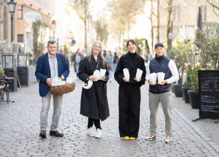 Team der IG Friedrich-Ebert-Straße verteilt Blumen auf dem Laurentiusplatz