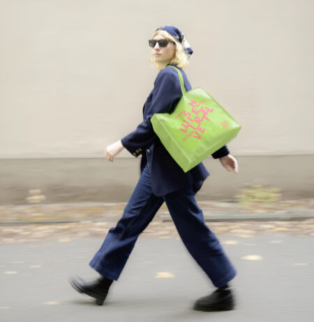 Ein Model geht mit einer Luisenviertel-Einkaufstasche über die Luisenstraße
